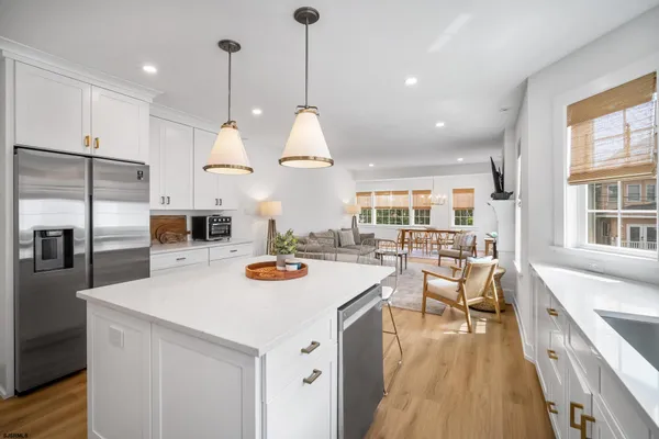 a kitchen with counter space appliances and a view of living room