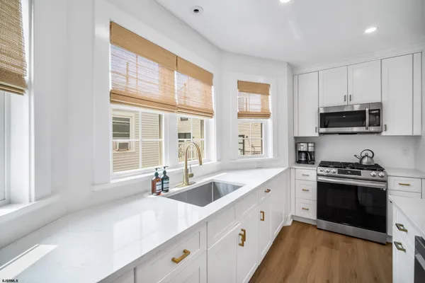 a kitchen with stainless steel appliances granite countertop a sink and a stove