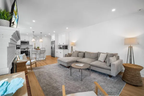 a living room with furniture and a view of kitchen