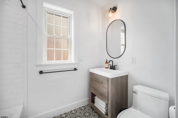 a bathroom with a sink toilet and a window