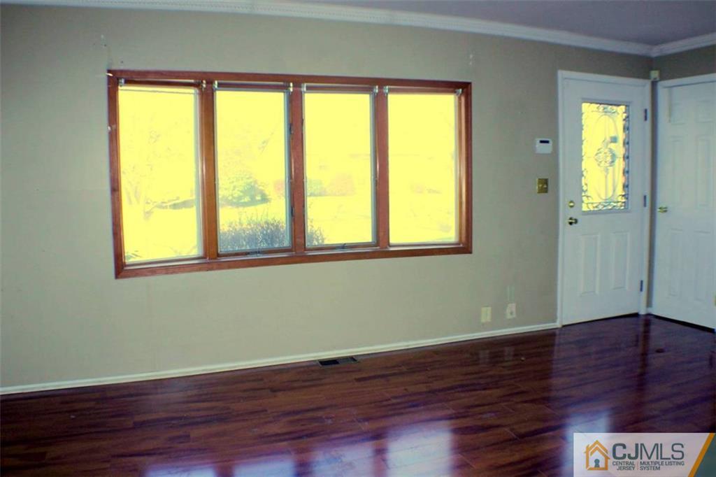 17 Rodney Road East Brunswick, NJ 08816 - Photo 14 of 16 a view of empty room with wooden floor and fan