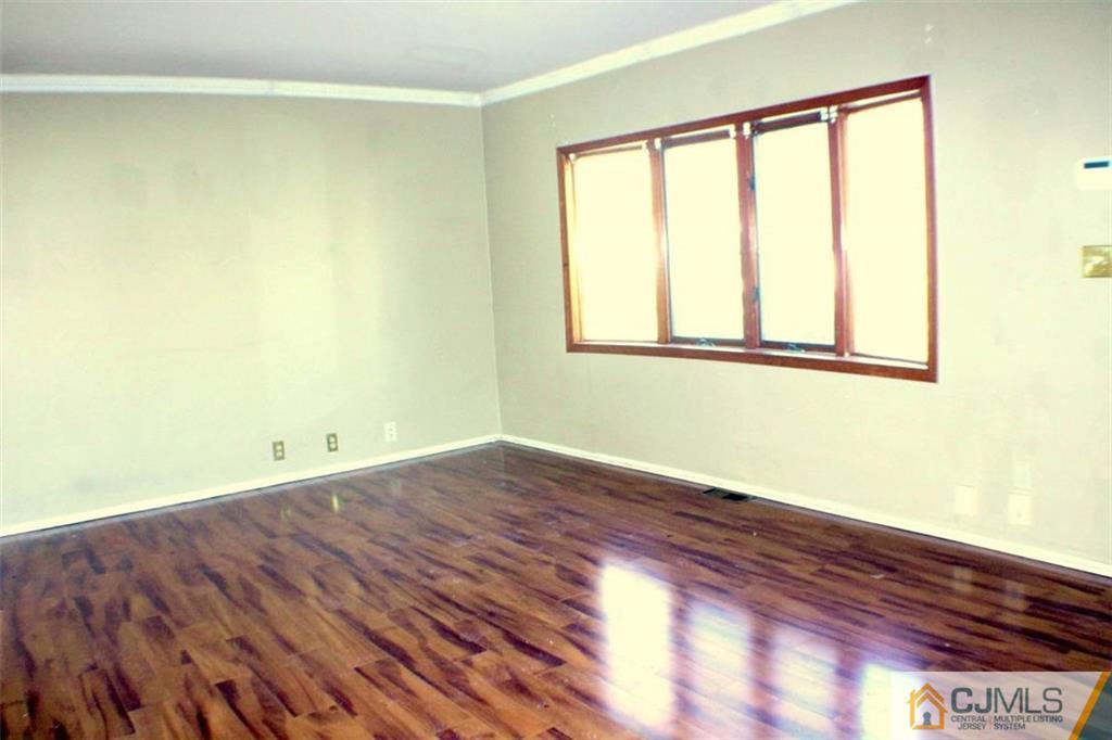 17 Rodney Road East Brunswick, NJ 08816 - Photo 15 of 16 a view of an empty room with wooden floor and a window