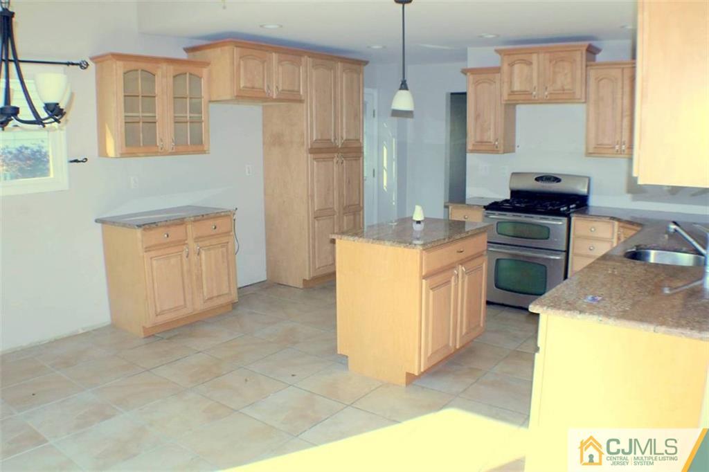 17 Rodney Road East Brunswick, NJ 08816 - Photo 5 of 16 a kitchen with a stove a sink and a refrigerator