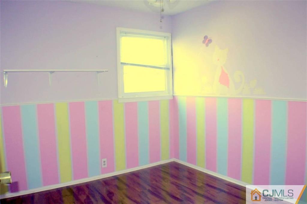 17 Rodney Road East Brunswick, NJ 08816 - Photo 7 of 16 a room with a window and wooden floor
