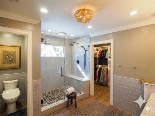 a bedroom with a bed a chandelier and a window