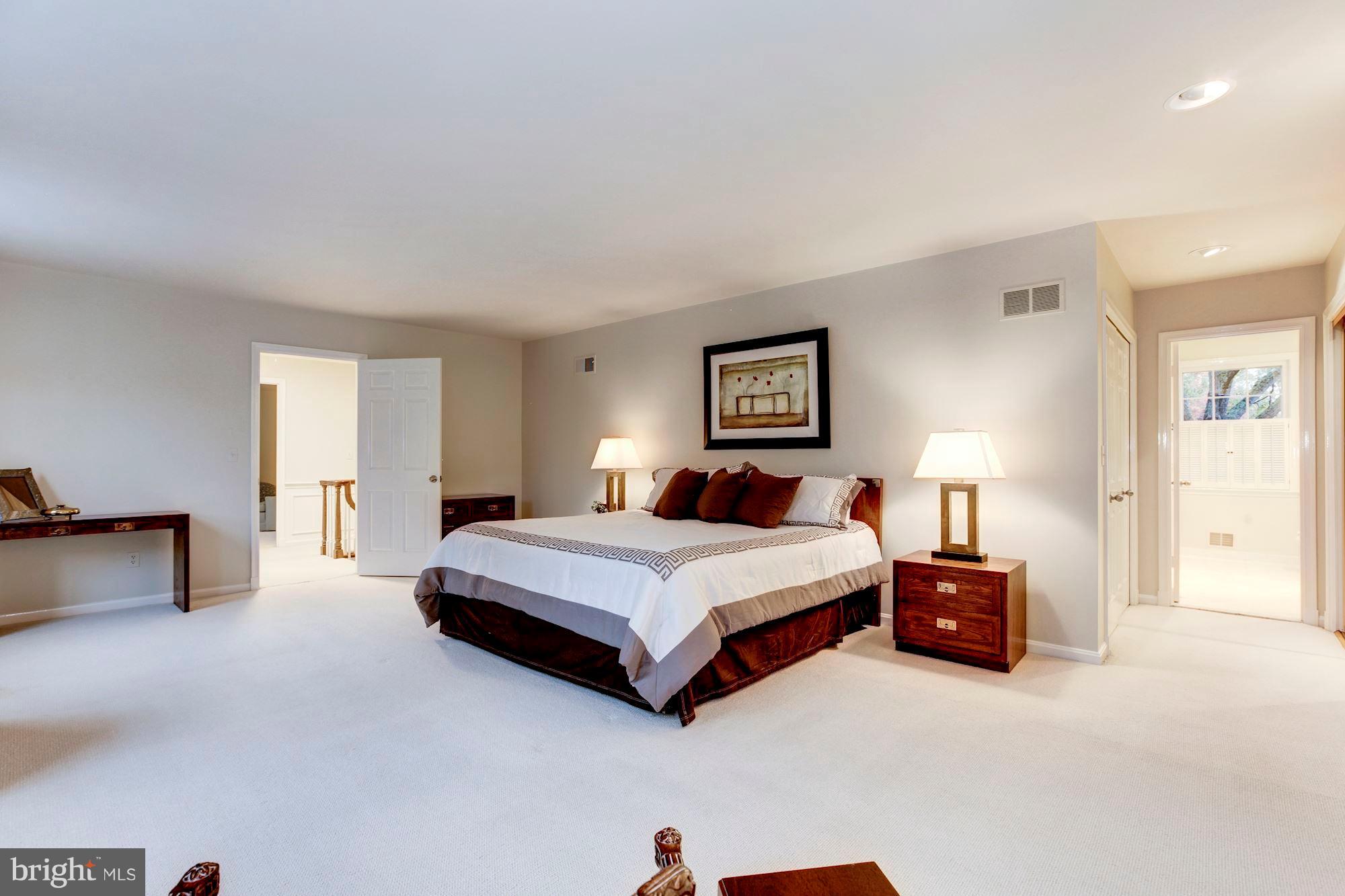 11000 Cripplegate Road Potomac, MD 20854 - Photo 25 of 44 a spacious bedroom with a bed and a lamp