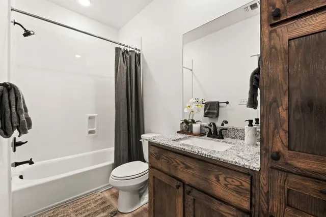 a bathroom with a granite countertop sink toilet and shower
