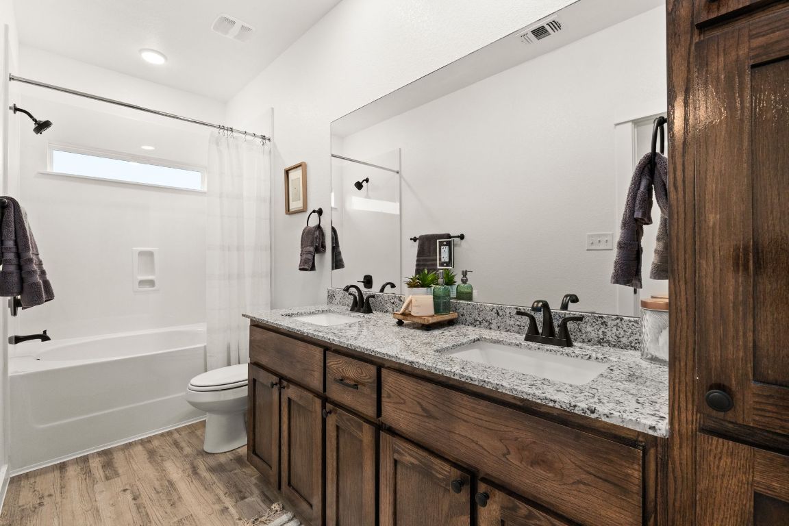 3602 Canvasback Road Killeen, TX 76542 - Photo 21 of 29 a bathroom with a granite countertop sink a toilet a mirror a vanity and bathtub