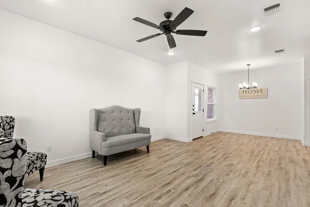 a living room with furniture and a ceiling fan