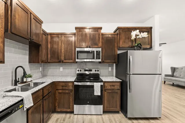 a kitchen with stainless steel appliances a refrigerator stove and sink