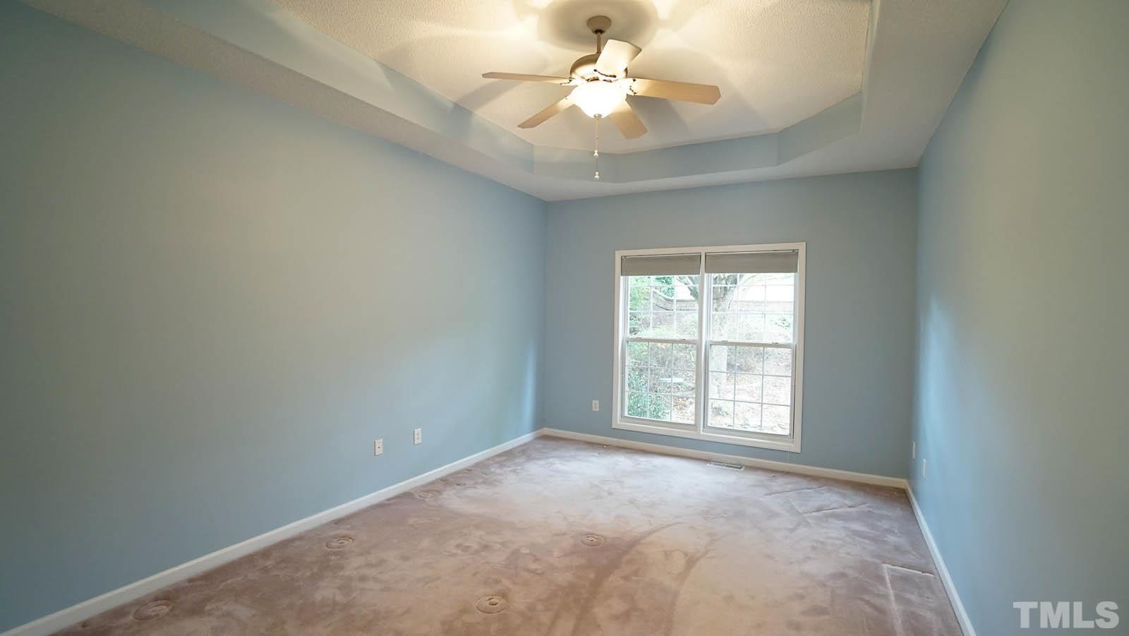 8316 Trumpetor Way Raleigh, NC 27613 - Photo 13 of 26 an empty room with windows and ceiling fan