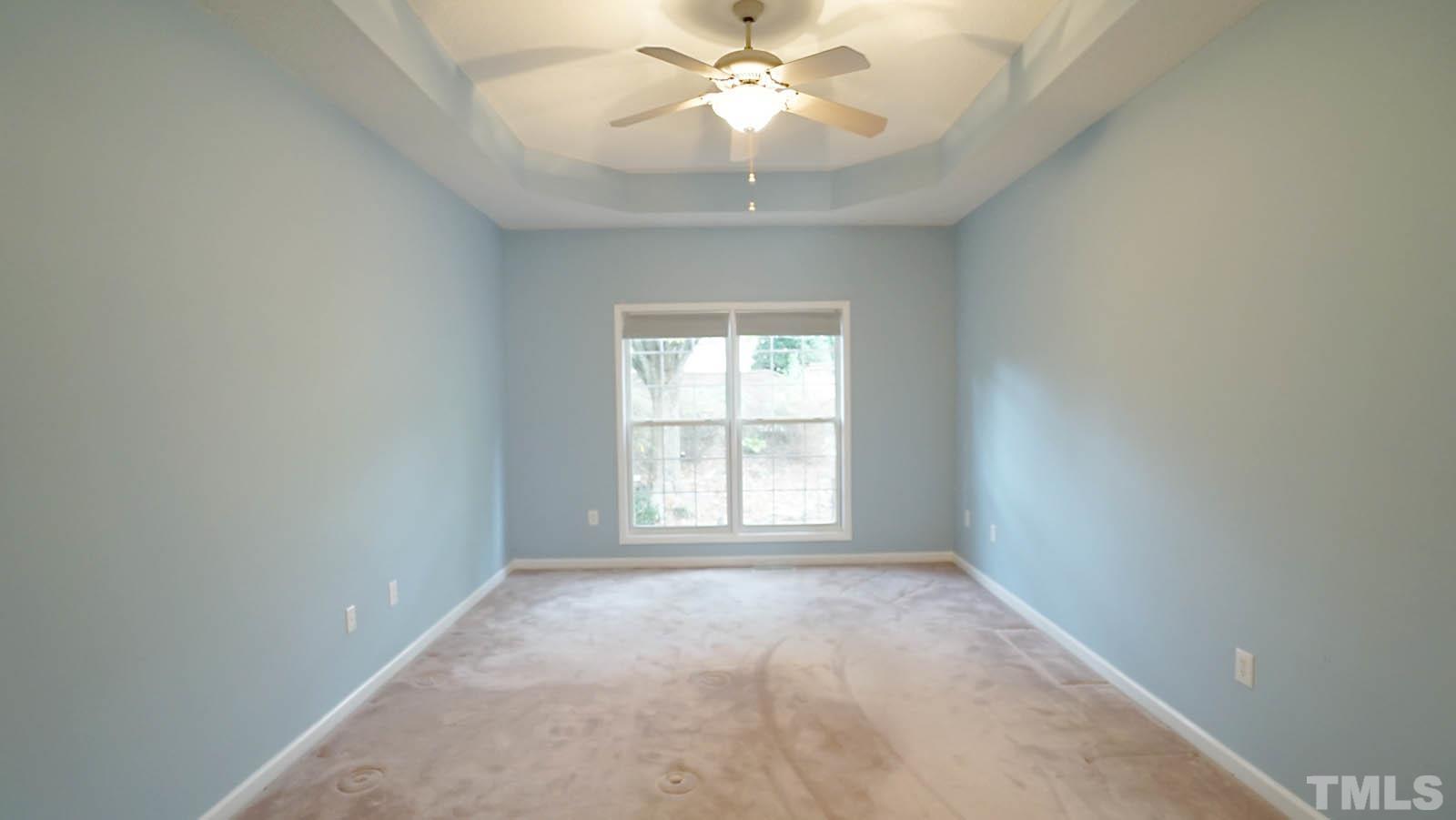 8316 Trumpetor Way Raleigh, NC 27613 - Photo 14 of 26 an empty room with a window and a fan