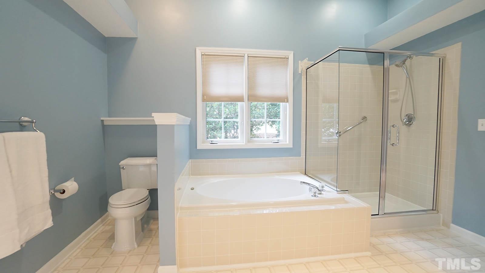 8316 Trumpetor Way Raleigh, NC 27613 - Photo 15 of 26 a bath room with a toilet and a bath tub