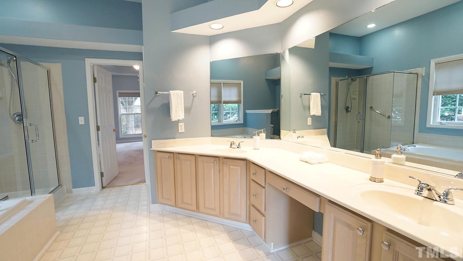 8316 Trumpetor Way Raleigh, NC 27613 - Photo 16 of 26 a bathroom with a granite countertop sink and a mirror