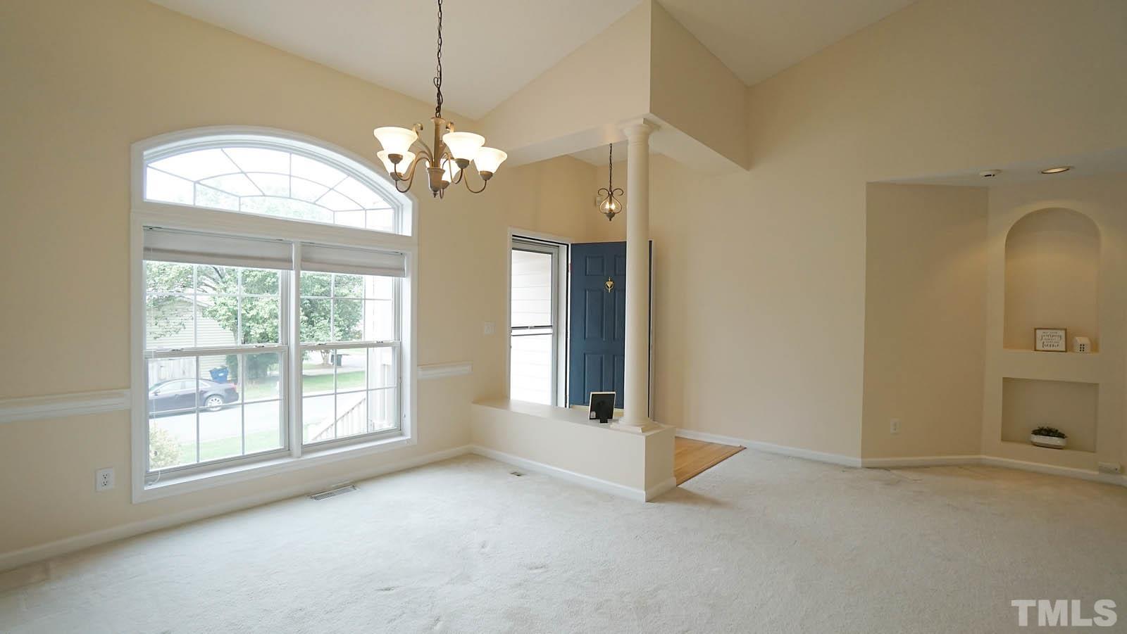 8316 Trumpetor Way Raleigh, NC 27613 - Photo 4 of 26 a view of a livingroom with a chandelier fan and windows