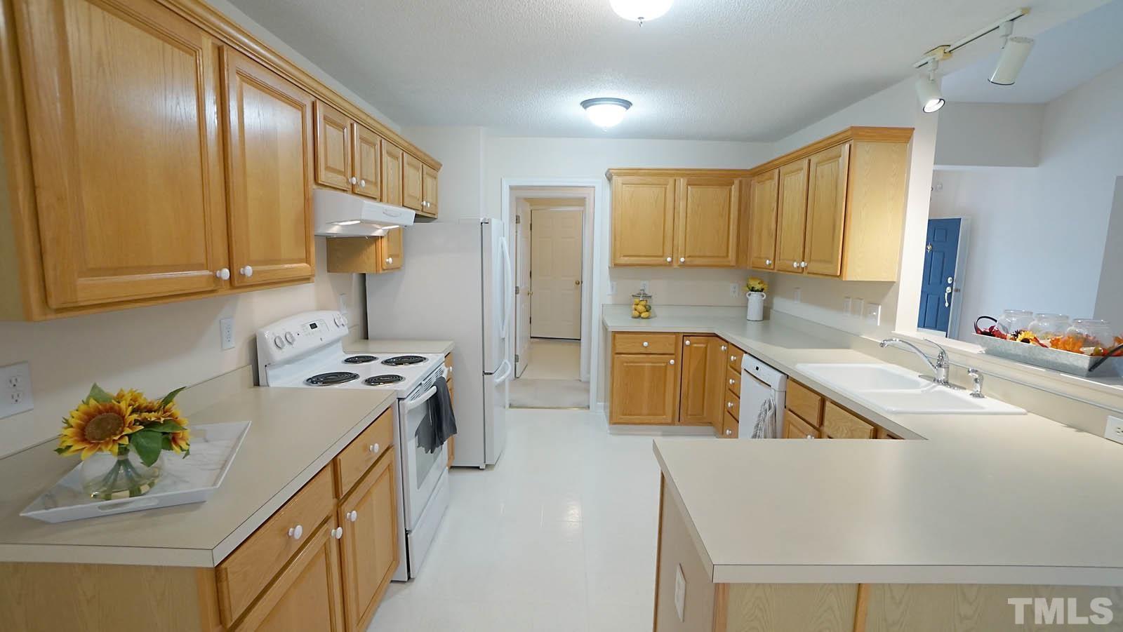 8316 Trumpetor Way Raleigh, NC 27613 - Photo 10 of 26 a kitchen with a sink a stove and a refrigerator