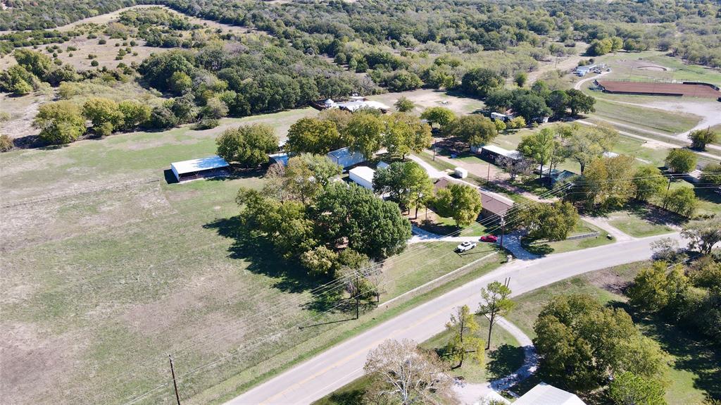 an aerial view of a house with a yard and greenery