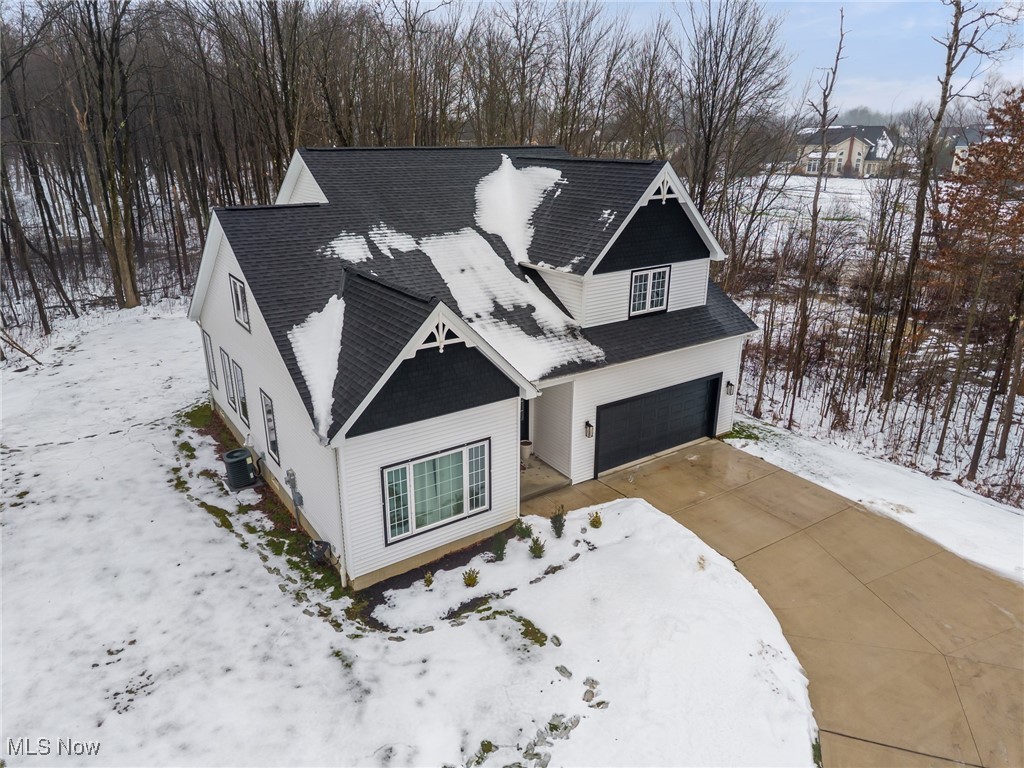 39600 Aurora Road Solon, OH 44139 - Photo 2 of 49 View of front of property featuring roof with shingles, an attached garage, and driveway