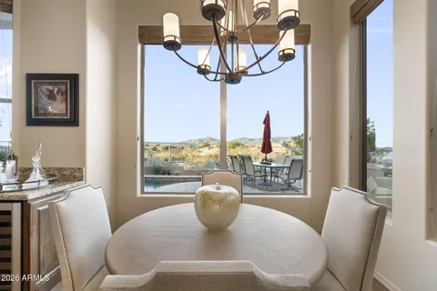a kitchen with stainless steel appliances a dining table chairs and stove