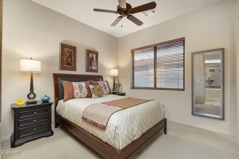 a spacious bedroom with a bed couch and a large window