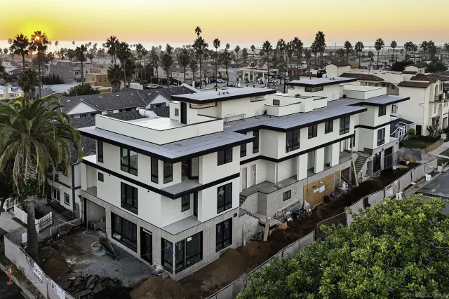 an aerial view of residential houses with outdoor space and trees