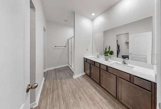 a bathroom with a double vanity sink and mirror
