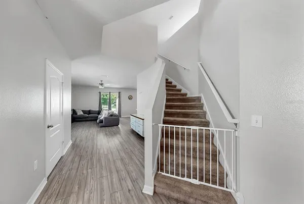a view of a livingroom with wooden floor and stairs