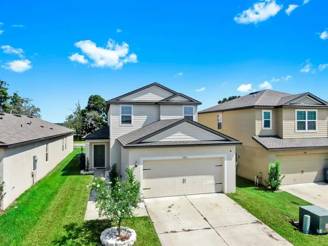 a front view of a house with a yard and garage