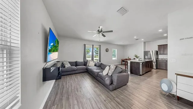a living room with furniture and a wooden floor