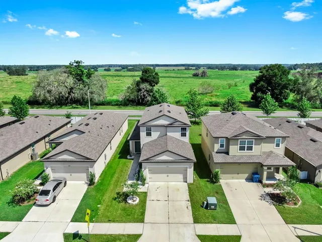 an aerial view of multiple houses with yard
