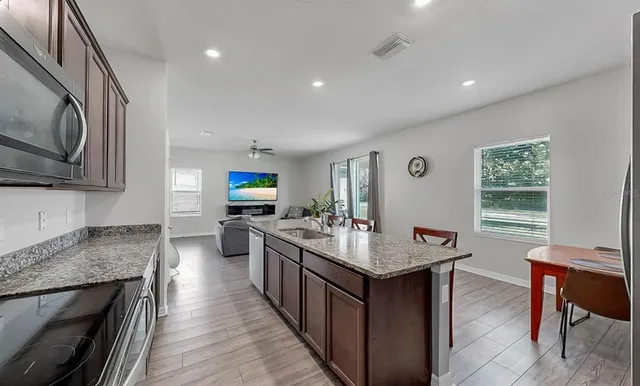 a kitchen with sink stove and refrigerator