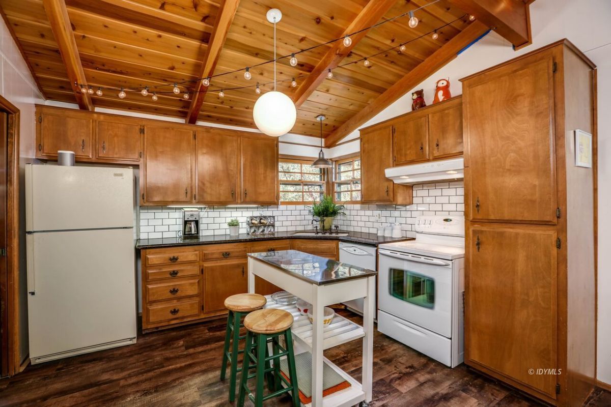 25405 Seneca Road Idyllwild, CA 92549 - Photo 14 of 61 a kitchen with granite countertop a refrigerator a sink and chairs