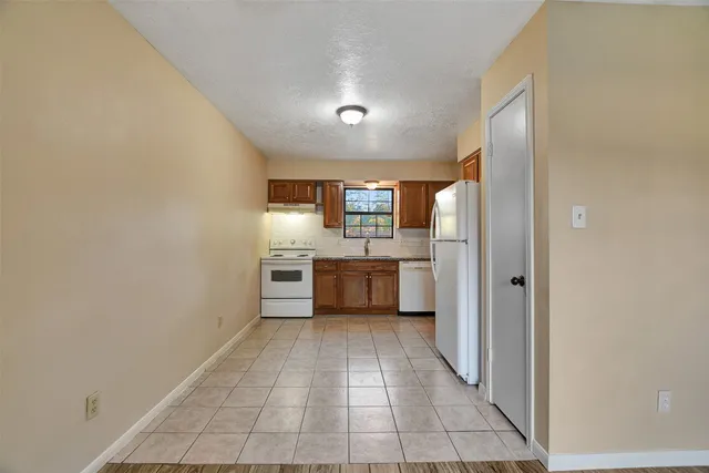 a view of a kitchen with a sink and a refrigerator