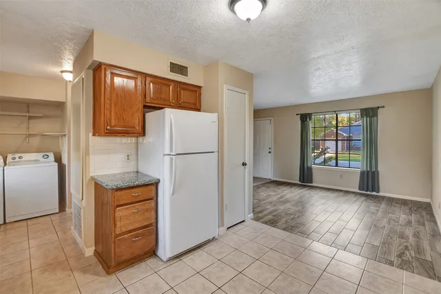 a kitchen with cabinets and refrigerator
