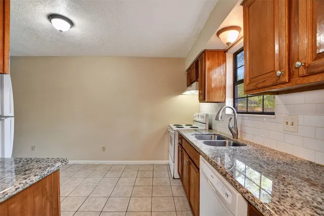 a kitchen with stainless steel appliances granite countertop a sink and a stove