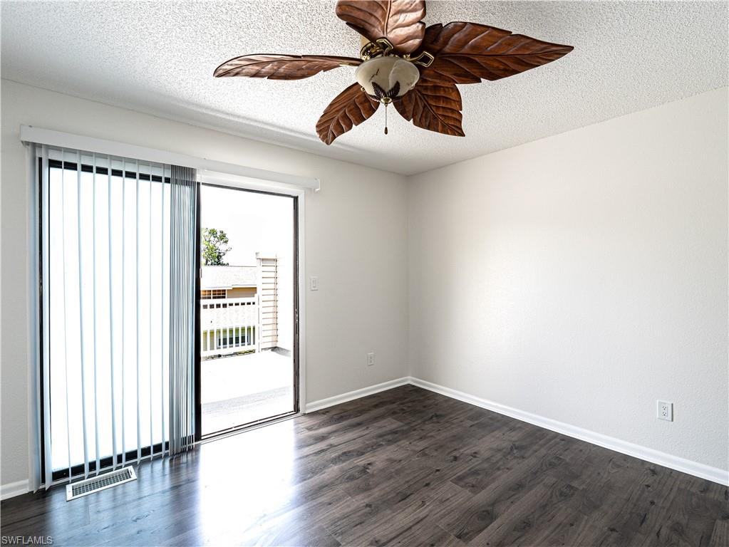 11001 Southeast Sunset Harbor Road, Unit 34 Summerfield, FL 34491 - Photo 20 of 31 Empty room featuring a textured ceiling, dark wood-type flooring, and ceiling fan