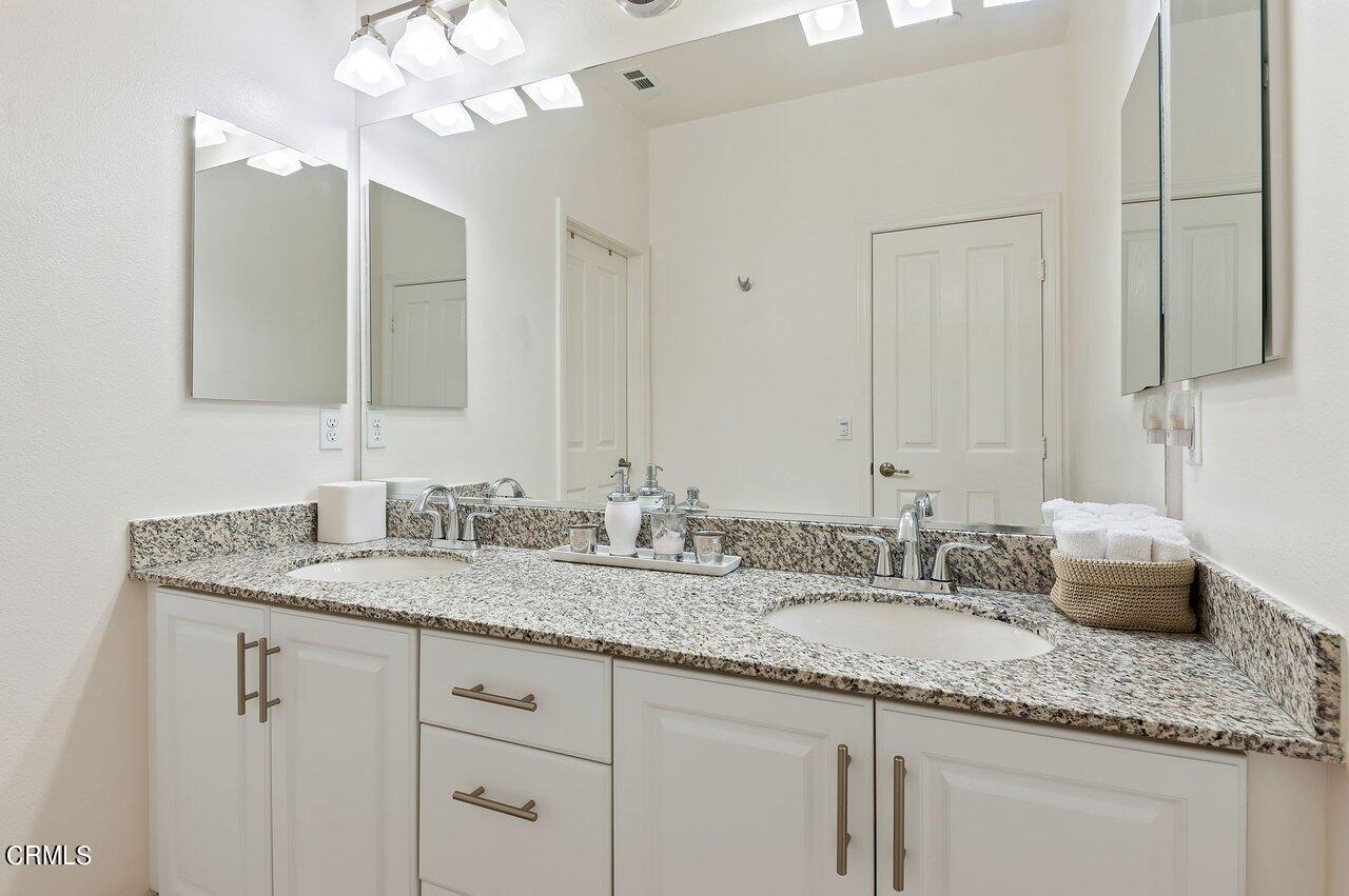 719 Forest Park Boulevard Oxnard, CA 93036 - Photo 20 of 39 a bathroom with a granite countertop double vanity and a mirror