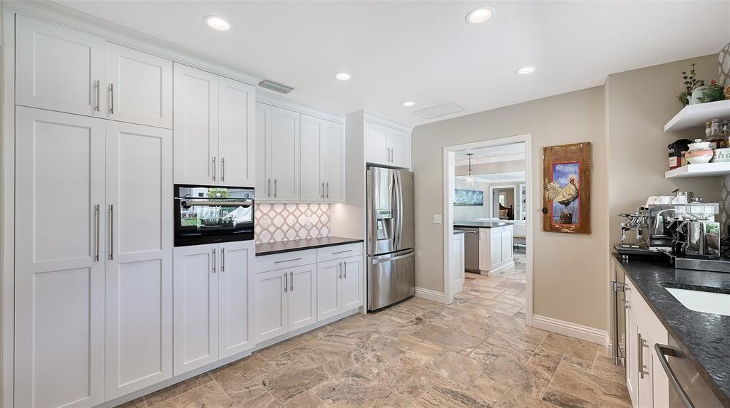 531 Wedge Lane Longboat Key, FL 34228 - Photo 10 of 28 a kitchen with white cabinets and refrigerator