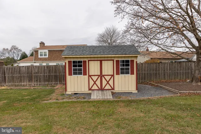 a view of a house with backyard and a tree