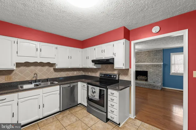a kitchen with stainless steel appliances white cabinets and a stove top oven
