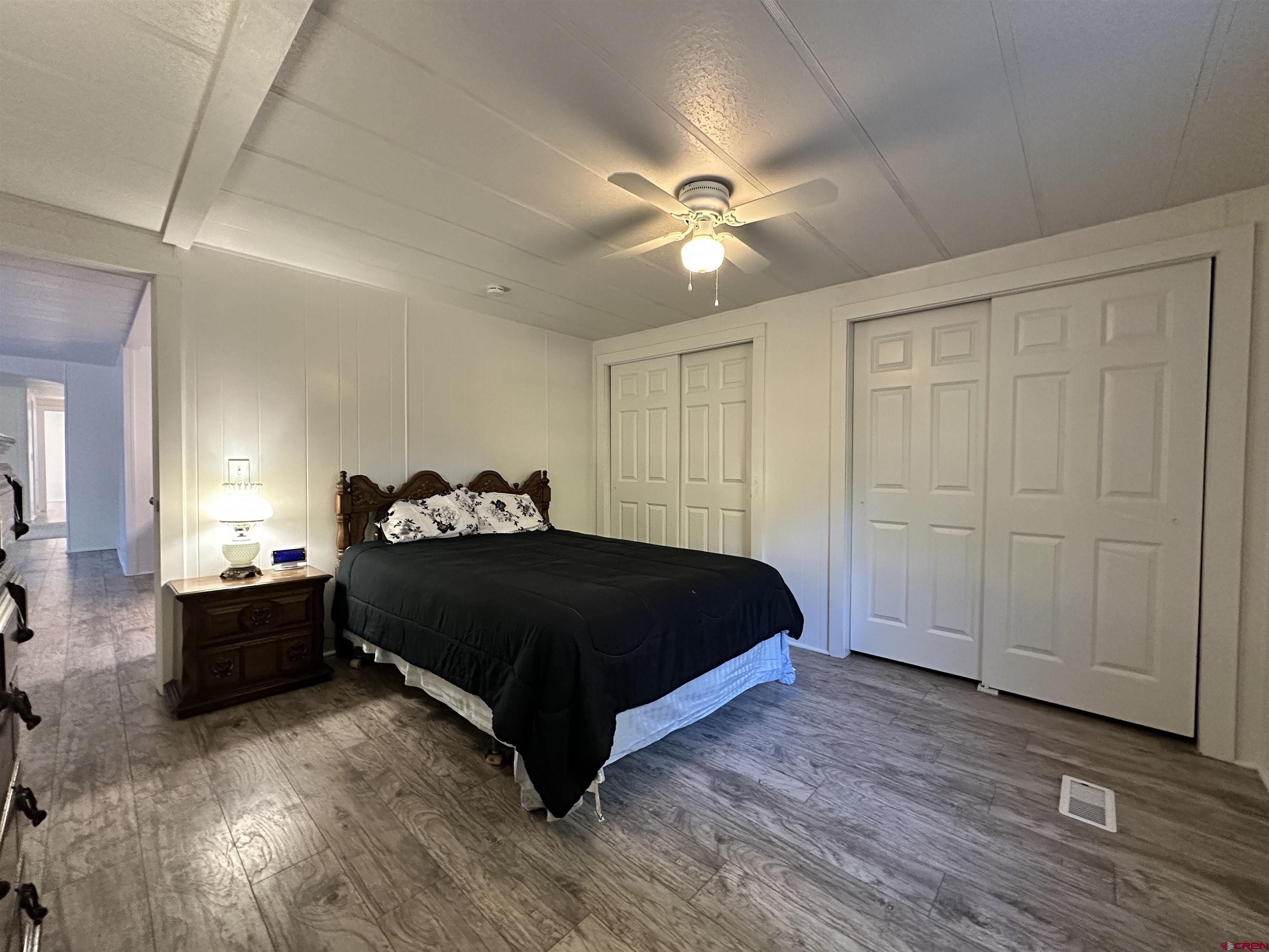 468 Rio Grande Road South Fork, CO 81154 - Photo 14 of 43 a spacious bedroom with a bed and a chandelier