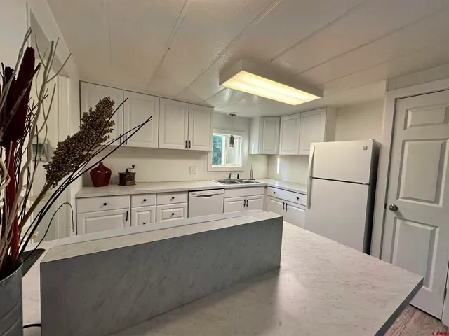 a kitchen with stainless steel appliances a refrigerator sink and cabinets