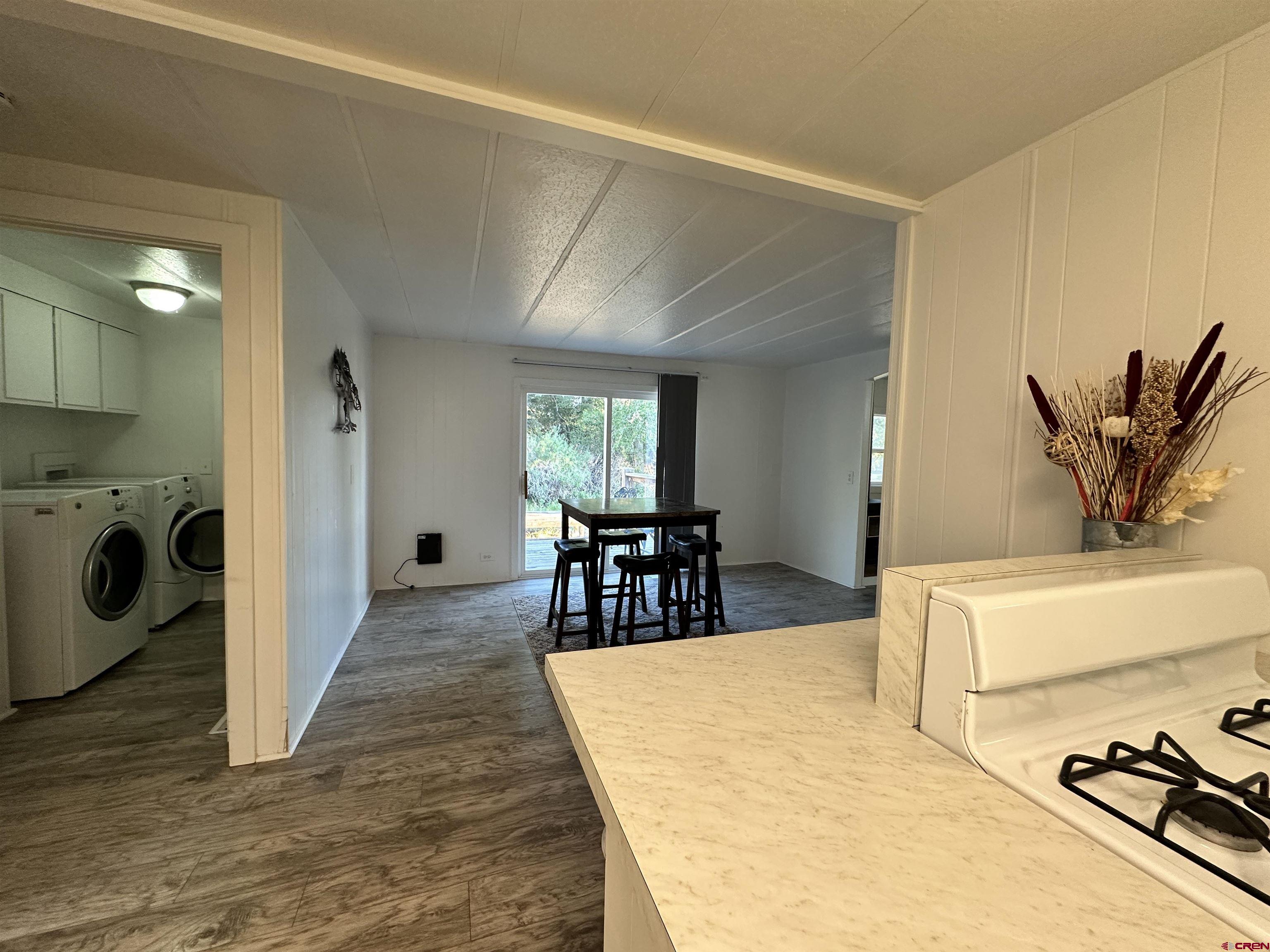 468 Rio Grande Road South Fork, CO 81154 - Photo 18 of 43 a living room with a couch and a dining table with wooden floor