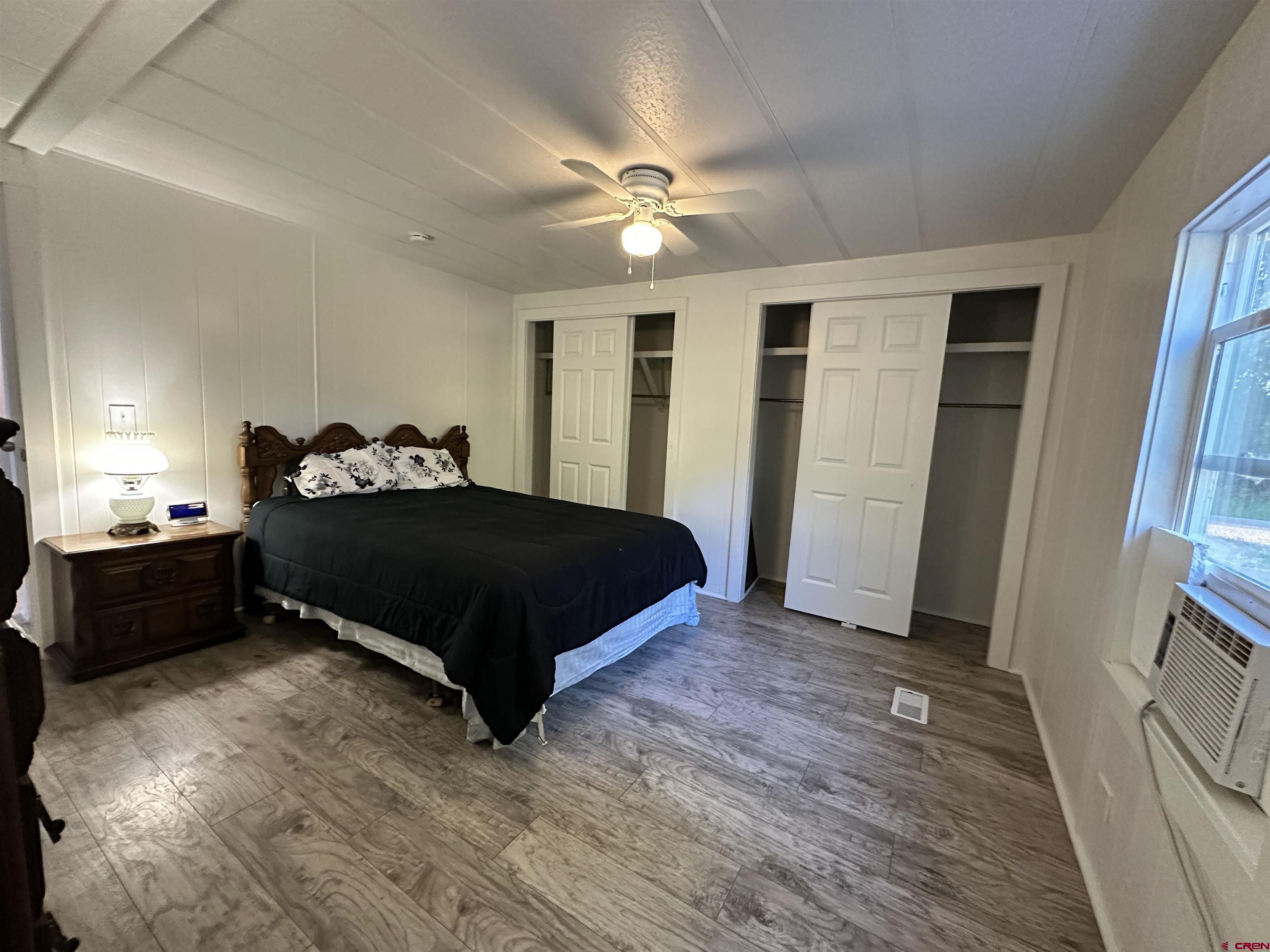 468 Rio Grande Road South Fork, CO 81154 - Photo 22 of 43 a bedroom with a bed and a chandelier