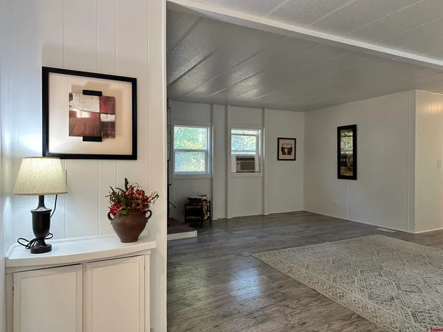 a view of a hallway with a flower pot and a flat screen tv