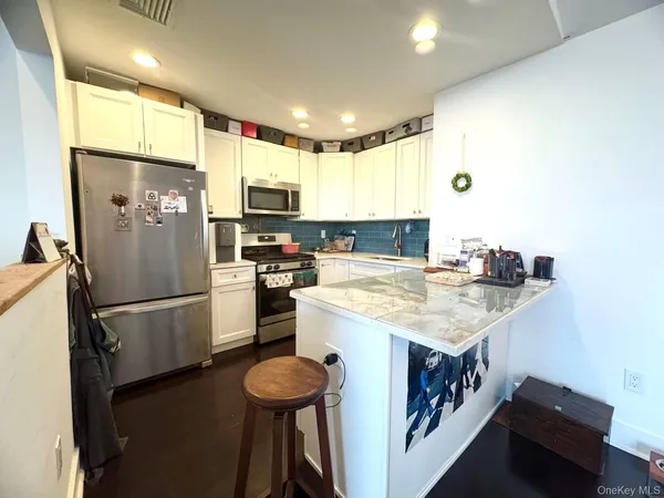a kitchen with a refrigerator a stove top oven a sink and cabinets