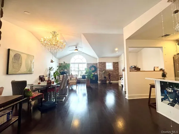 a living room with lots of furniture hardwood floor and a kitchen view