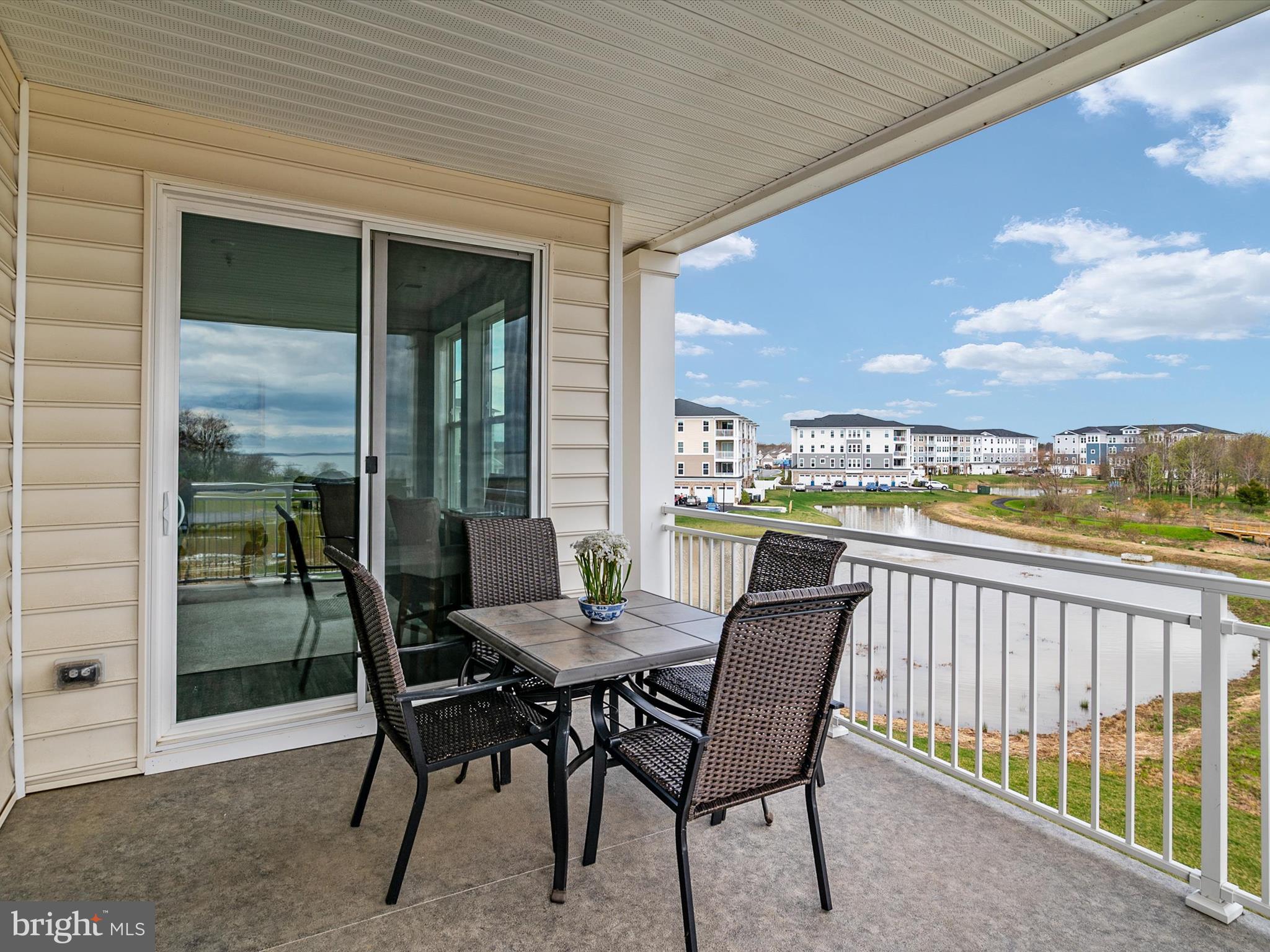 141 Switchgrass Way, Unit 34 Chester, MD 21619 - Photo 33 of 61 a view of a balcony with furniture and a floor to ceiling window