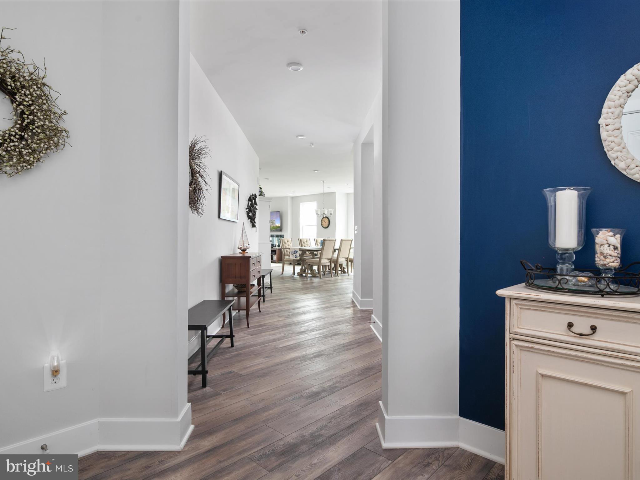 141 Switchgrass Way, Unit 34 Chester, MD 21619 - Photo 10 of 61 a view of a hallway with wooden floor a fireplace and a potted plant