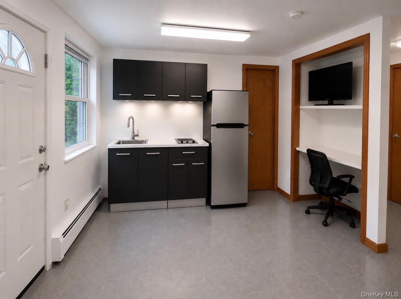 176 Spackenkill Road, Unit 1B Poughkeepsie, NY 12603 - Photo 1 of 7 a living room with a flat screen tv and refrigerator